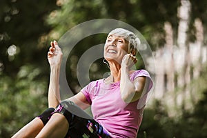 Woman exercising in park while listening to music