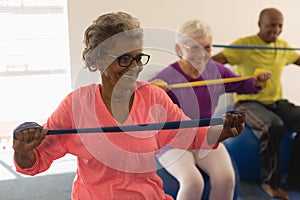 Senior woman exercising with resistance band in fitness studio