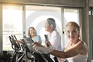 Senior woman exercising spinning bike in fitness gym. elderly healthy lifestyle concept