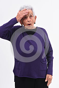 Senior woman with expression of forgetfulness or surprise on white background