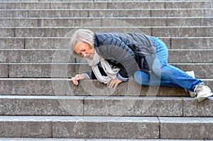 Senior woman falling down stone steps outdoors