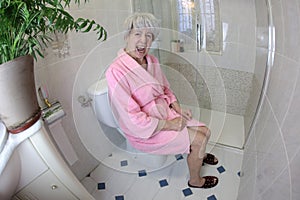 Senior woman feeling constipated in the bathroom