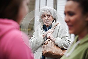 Senior Woman Feeling Intimidated By Teenage Girls