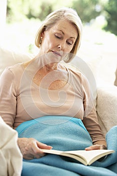 Senior Woman Feeling Unwell Resting Under Blanket