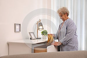 Senior woman finding bananas in chest of drawers at home. Age-related memory impairment