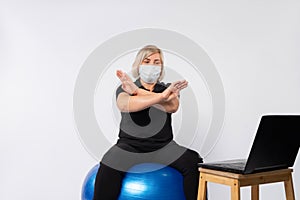 Senior woman, fitness at home, medical mask shows stop virus. White background