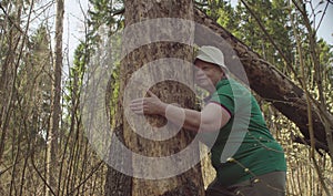 Senior woman in the forest hugging a damaged tree