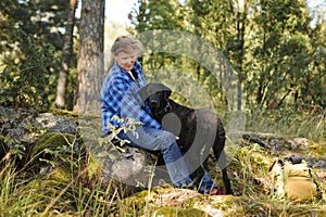 Senior woman in forest with pet dog