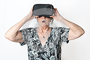 Senior woman gesturing while wearing virtual reality headset isolated on isolated white background