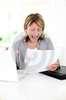 Senior woman getting crazy with paperwork