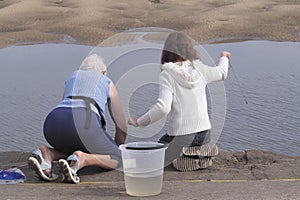 Senior woman and girl on beach