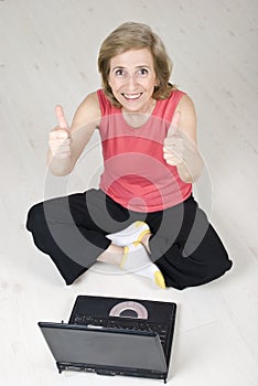 Senior woman giving thumbs up using laptop