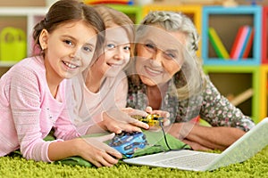 senior woman with granddaughters playing video game