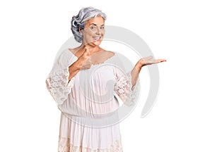 Senior woman with gray hair wearing bohemian style showing palm hand and doing ok gesture with thumbs up, smiling happy and