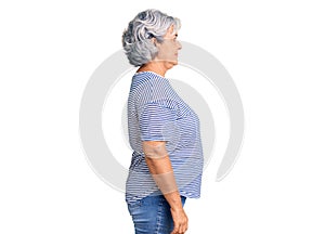 Senior woman with gray hair wearing casual striped clothes looking to side, relax profile pose with natural face with confident