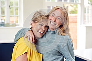 Senior Woman Greeting And Hugging Grown Up Adult Daughter At Home