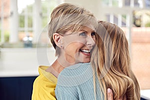 Senior Woman Greeting And Hugging Grown Up Adult Daughter At Home