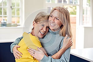 Senior Woman Greeting And Hugging Grown Up Adult Daughter At Home