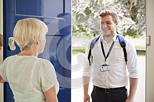 Senior woman greeting male care worker making home visit