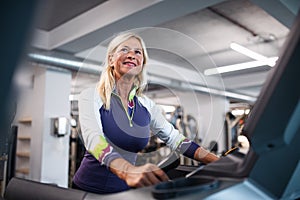 A senior woman in gym doing cardio work out exercise.