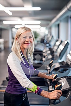 A senior woman in gym doing cardio work out exercise.