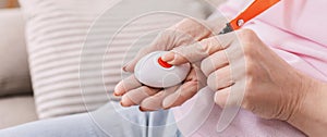 Senior woman hand pressing Alarm Button, closeup