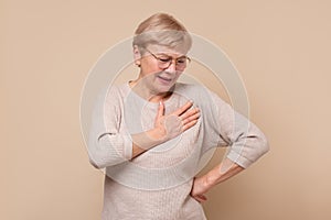 Senior woman with hands on chest having pain.