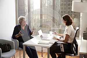 Senior Woman Having Consultation With Female Doctor In Hospital Office