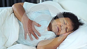 Senior woman having heart problem in bed