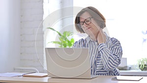 Senior Woman having Neck Pain while using Laptop