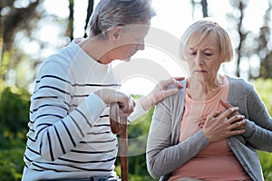 Senior woman having pain in her chest outdoors