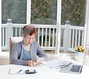 Senior woman having stress looking at her financial bills