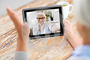 Senior woman having video call on tablet computer