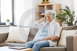 Senior woman in headphones listening to music