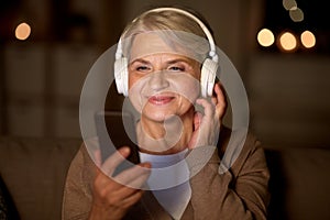 Senior woman in headphones listening to music
