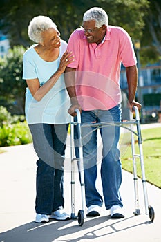 Senior Woman Helping Husband With Walking Frame