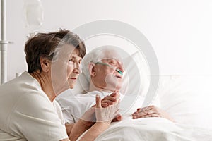Senior woman and her dying husband