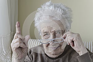 Senior woman with her finger up for admonition / warning photo