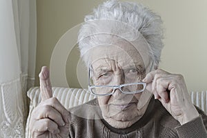 Senior woman with her finger up for admonition / warning photo