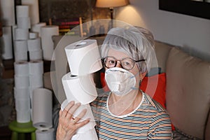 Senior woman hoarding toilet paper rolls