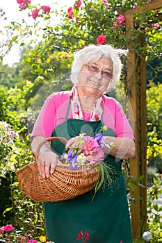 Senior woman holding basket in garden