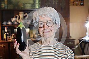 Senior woman holding a delicious eggplant