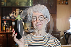 Senior woman holding a delicious eggplant