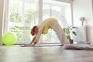 Senior woman holding downward facing dog yoga position