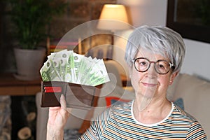 Senior woman holding full wallet