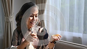 Senior woman holding glass of fresh water, taking dietary supplements. Elderly healthcare, medication concept