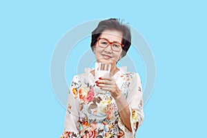 Senior woman holding a glass of milk