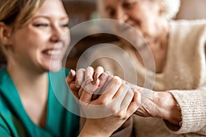 Senior woman holding hands with a nurse