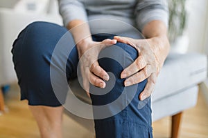 Senior woman holding her painful knee