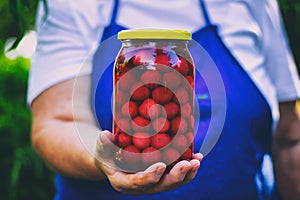 Senior woman holding a jar of cherry compote